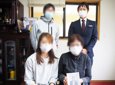 ご自宅に今でも飾られているパネルの前で(後列左から2番目がご長女様、前列左端が担当した中尾さん)
