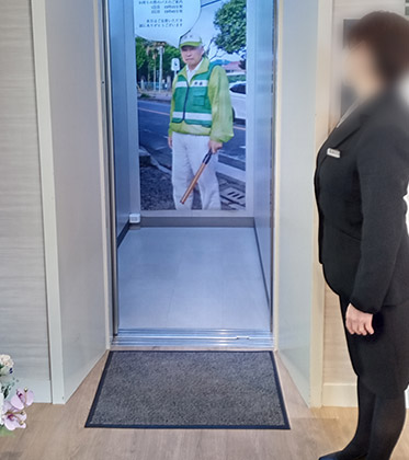 エレベーターの中の、父の等身大写真パネル。開式前は白い吹き出し部分に帰りのバスの時刻表が貼られていましたが、閉式後は「気をつけてな~」の言葉が。
